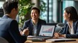 © NAD SANG PAP - Smiling businesspeople working together on a laptop in an office