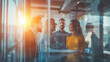 © Robert Kneschke - Team discussion at a business meeting behind glass wall with sunlight