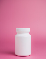 Wall Mural - White medical plastic jar against pink backdrop. Packaging for drugs, vitamins. Pill container.