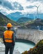© ParinApril - A construction worker observes a large dam surrounded by mountains and wind turbines, highlighting renewable energy efforts.