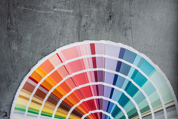 Rainbow catalog of paints with a various color palette on grey desk