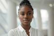© LukaszDesign - Confident young mixed race businesswoman standing alone in an office, displaying a serious expression while at work