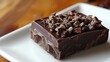 © JERRYsnipe.AI - A decadent piece of dark chocolate topped with cacao nibs, highlighting the rich textures and intense flavors of highquality chocolate