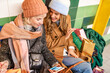 © Lomb - Friends winter shopping using smartphone colorful bags fashion accessories