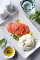 Sticker - Delicious burrata cheese and grapefruit served on light grey table, top view