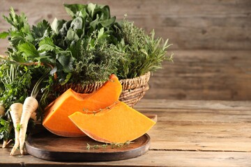 Wall Mural - Different fresh herbs and pumpkin on wooden table, space for text