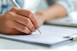 © LidiaLens - Close-up of a businesswoman's hand writing on a document with a pen in a professional setting, emphasizing focus, precision, and attention to detail in paperwork and administrative tasks