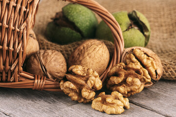 Wall Mural - Walnut kernels and whole walnuts on rustic wooden table. Healthy walnuts.