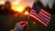 © yahya - Hand Holding Lit Sparkler with American Flag Background