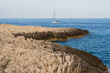 © Dmitri - Rocky impassable coast and sailing yacht in the Mediterranean Sea in the south of France near the coast of Saint Jean Cap Ferrat.