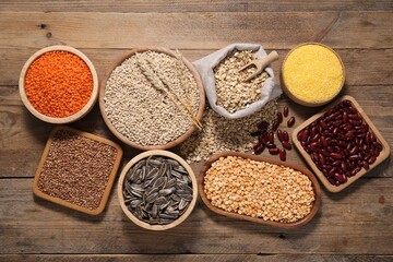 Sticker - Different types of cereals, seeds and legumes on wooden table, flat lay