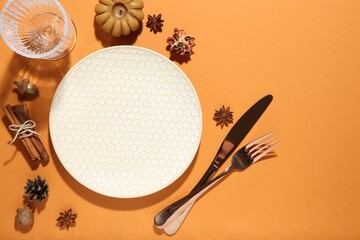 Wall Mural - Beautiful table setting with autumn decor on orange background, flat lay