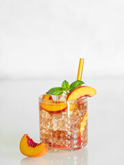 Canvas Print - Peach refreshing drink with ice and mint on a white background. Fresh homemade lemonade in a glass.