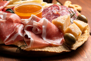 Tagliere con prosciutto crudo, parmigiano, salame e pecorino, antipasti italiani, gastronomia europea 