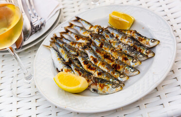 Sticker - Malaga cuisine grilled sardines served with lemon on white plate on wooden table