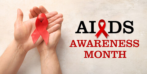 Wall Mural - Male hands with red ribbon on grunge white background. Blood Cancer Awareness Month