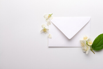 Wall Mural - Composition with envelope and beautiful jasmine flowers on light background