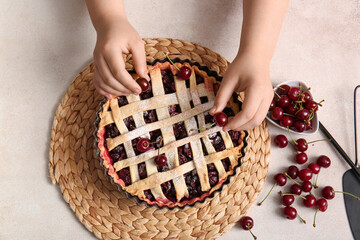 Poster - Woman decorating tasty cherry pie on white background