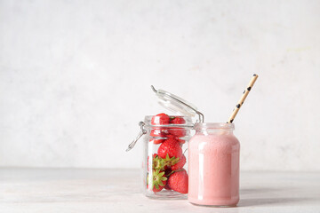 Wall Mural - Mason jar of tasty strawberry smoothie on light background
