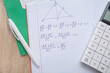 © Pixel-Shot - Open copybook with formulas, calculator and pen on wooden table