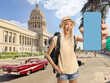 © Ljupco Smokovski - Female backpacker holding a smartphone with blue screen on the streets of Havana