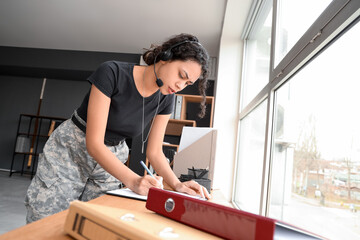 Wall Mural - Female African-American soldier working with headset at headquarters