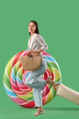 Sticker - Smiling young woman with bag and inflatable mattress on green background