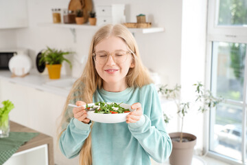 Sticker - Young woman holding plate of tasty salad with feta cheese in kitchen