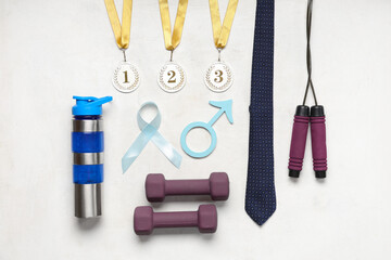 Wall Mural - Tie, dumbbells, water bottle, medals, male sign and light blue ribbon on white background. Prostate cancer awareness