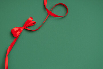 Poster - Bow made of red ribbon on green background