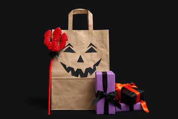 Canvas Print - Paper shopping bag, gifts and devil pitchfork on dark background