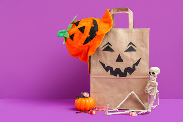 Sticker - Composition with paper shopping bag, decorations and sweets for Halloween on purple background