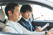 © buritora - 教習所で指導する教官と運転免許を取得するため受講する中年の男性ドライバー