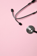 Wall Mural - Stethoscope on pink background, top view. Space for text