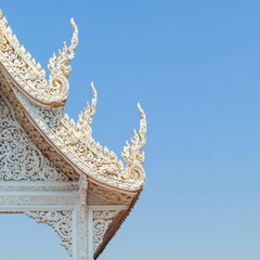 Wall Mural - Ornate Roof Detail of Thai Temple Against Blue Sky