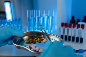 Wall Mural - a scientist is testing various pills in order to improve their quality an effectiveness in the labor