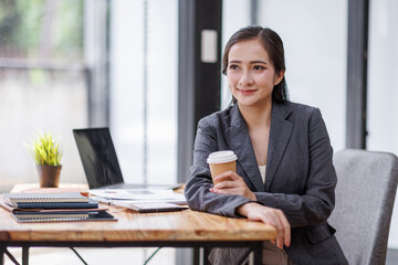 Wall Mural - Happy Asian Business woman using calculator and laptop for doing math finance on an office desk, tax, report, accounting, statistics, and analytical research concept