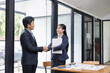 © SOMKID - Two Asian business people and working together standing in office, Startup projects and business presentation.