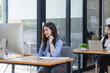 © SOMKID - Young asian businesswoman with headset using desktop computer for customer support and online working in office, Call center helping for customers online concept.