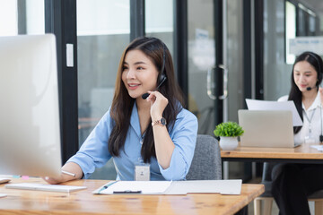 Young asian businesswoman with headset using desktop computer for customer support and online working in office, Call center helping for customers online concept.