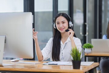 Young asian businesswoman with headset using desktop computer for customer support and online working in office, Call center helping for customers online concept.