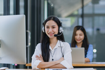 Young asian businesswoman with headset using desktop computer for customer support and online working in office, Call center helping for customers online concept.