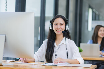 Young asian businesswoman with headset using desktop computer for customer support and online working in office, Call center helping for customers online concept.