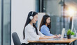 © SOMKID - Young asian businesswoman with headset using desktop computer for customer support and online working in office, Call center helping for customers online concept.