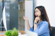 © SOMKID - Young asian businesswoman with headset using desktop computer for customer support and online working in office, Call center helping for customers online concept.