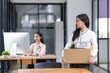 © SOMKID - Young asian woman employee with a storage box for the equipment after resigning and stressed from work.