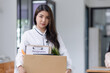 © SOMKID - Young asian woman employee with a storage box for the equipment after resigning and stressed from work.