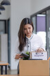 © SOMKID - Young asian woman employee with a storage box for the equipment after resigning and stressed from work.