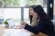 © SOMKID - Two Asian businesswomen working on laptop computer with analyzing financial charts in the modern office, Business financial documents and planning idea project concept.