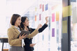 © SOMKID - Two Asian young businesswomen with analyzing financial data charts and business presentation plan in the modern office, Business financial documents and planning idea project concept.